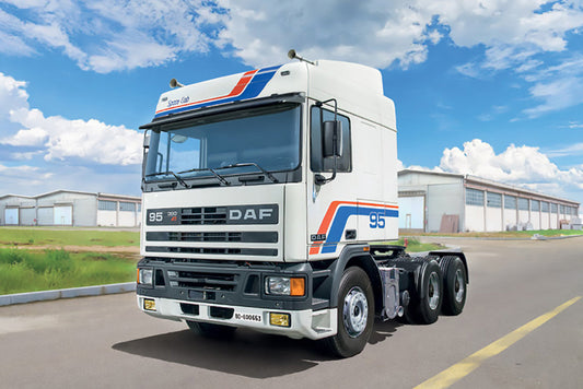 DAF truck on a road with a clear sky and buildings in the background