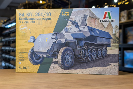 Model tank kit packaging with Italeri branding on a wooden surface.