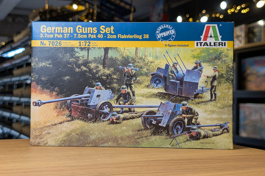 Model kit box for German guns set by Italeri on a wooden surface with blurred background